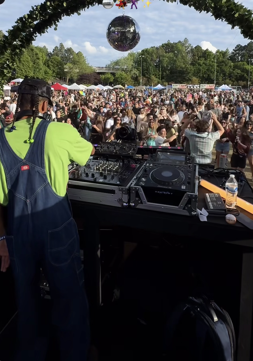 DJ perspective from behind the decks looking at a festival crowd